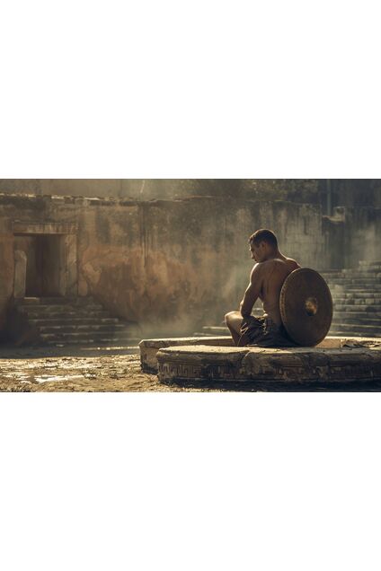 A solitary gladiator seated on a stone bench in a quiet training yard after exertion, head lowered slightly, posture controlled rather than exhausted, discarded shield resting nearby, the scene calm and reflective, emphasizing restraint, consequence, and earned endurance